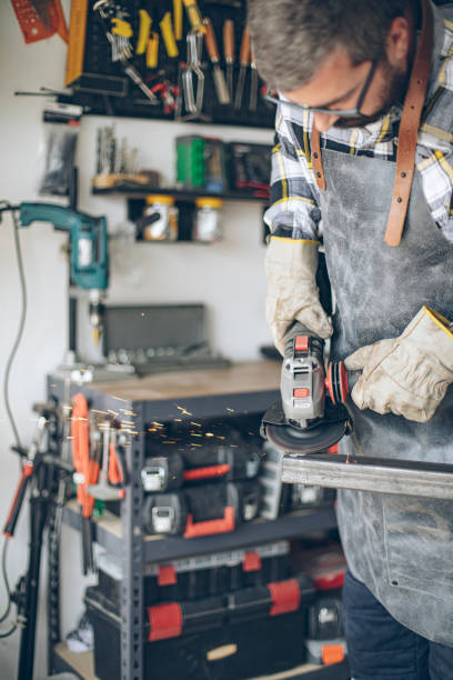 istock Craftsman cutting metal and using angle grinder in home workshop 1487531373