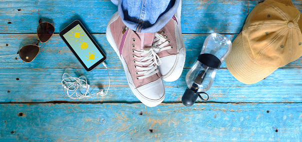 Summer,spring or vacation concept.Leisure clothing, sneakers, smartphone,sunglasses, water bottle, flat lay,copy space