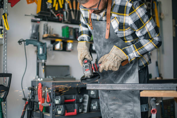 istock Craftsman cutting metal and using angle grinder in home workshop 1487532102