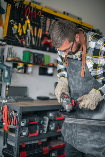 istock Craftsman cutting metal and using angle grinder in home workshop 1487532255