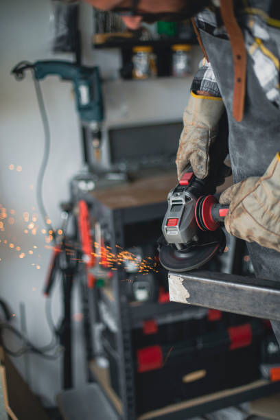 istock Craftsman cutting metal and using angle grinder in home workshop 1487532391