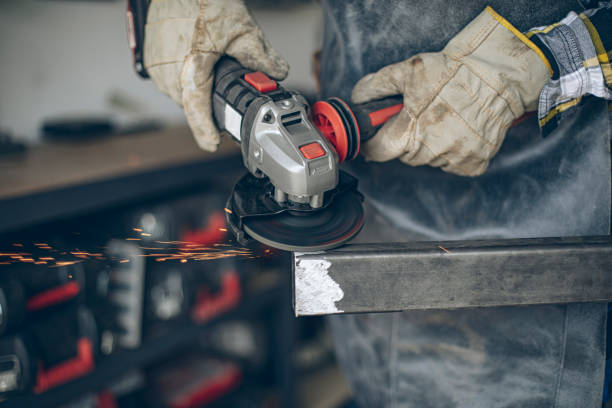 istock Close up of craftsmans hands cutting metal and using angle grinder in home workshop 1487532559