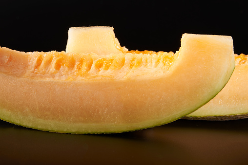 Close-up of two golden and juicy pieces of Hami melon