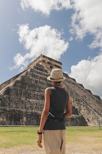 Teenage girl contemplating the pyramid  of Kukulcan in Chichen Itza, Mexico