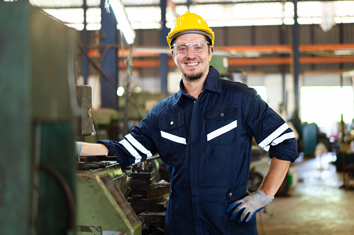 Senior professional mechanical engineer or technician working in the heavy metal work machine in a factory.