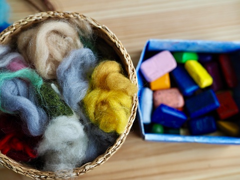 small basket with a set of colored wool for felting handcraft