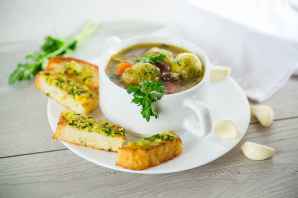 istock Hot cooked soup with Brussels sprouts, vegetables and croutons, in a plate. 1487539557