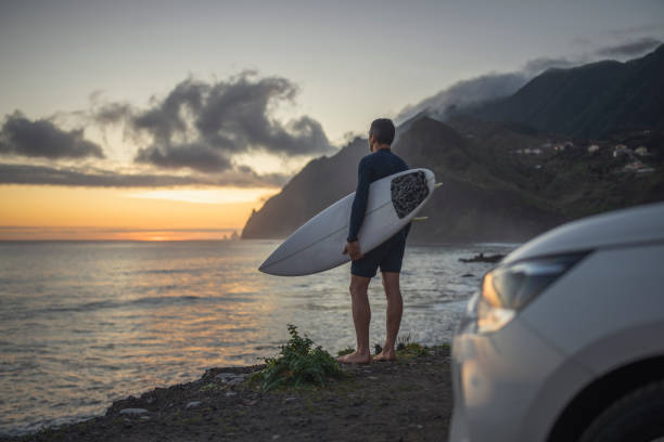 istock Surfer with surfboard looking at the ocean at dawn. 1487540425
