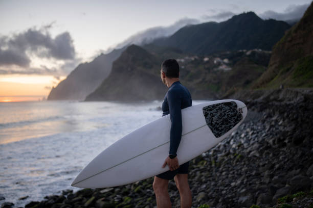 istock A middle aged surfer looks out towards the beach. 1487540429