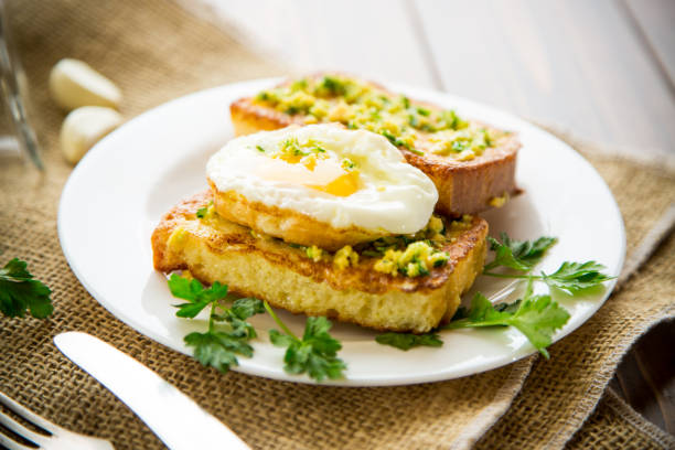 istock Fried croutons in batter with garlic and herbs and a fried egg in a plate. 1487540507