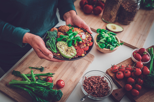 Close up of woman's hands holding a healthy plant-based salad plate. Healthy eating concept. High resolution 42Mp indoors digital capture taken with SONY A7rII and Zeiss Batis 40mm F2.0 CF lens