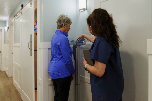 노인 환자의 체중을 측정하는 진료실의 간호사 - dieting weight scale doctor patient 뉴스 사진 이미지