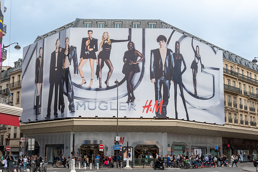 Paris, France - May 4, 2023: Advertising campaigns in Paris, France: Mugler giant billboard covering the H and M building