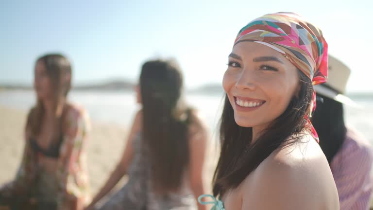 Portrait of mid adult woman with friends on the beach