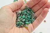 Green aventurine semi-precious natural polished gemstone mineral rock on hand of woman. Heart Chakra healing crystals