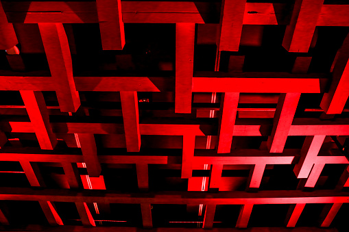 istock Background of geometric structure of beams in red and black 1487555207