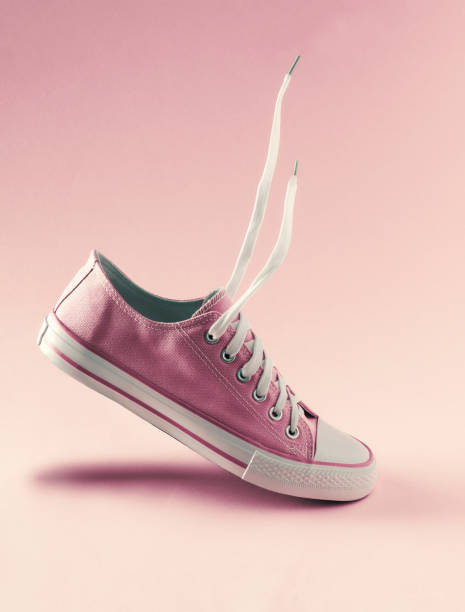 istock A classic pink sneaker floats in the air on a pink background. 1487556686