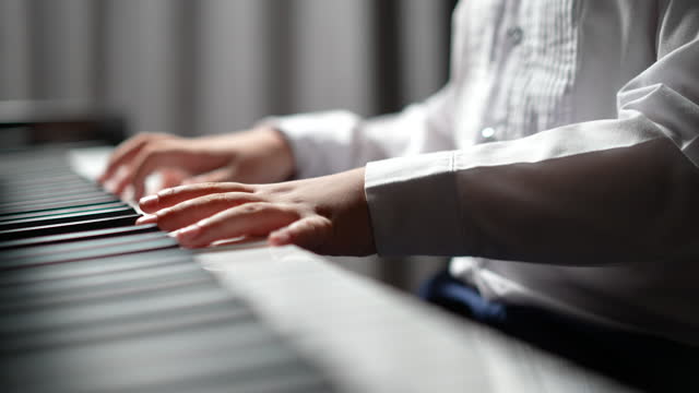 Asian boy practice playing piano at home