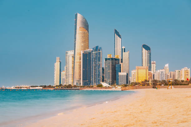 panoramic view of stunning sandy beach near corniche seaside embankment with great sunset view of abu dhabi, uae towering skyscrapers - abu dhabi stok fotoğraflar ve resimler