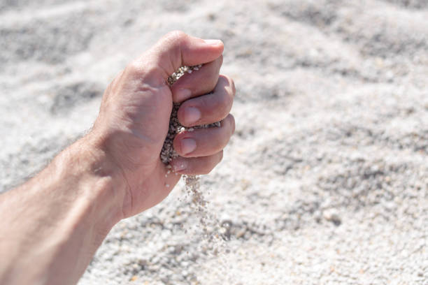 istock Close-Up of a Hand Dropping Coarse Sand 1487558474