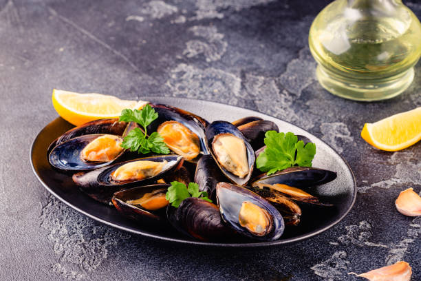 délicieuses moules de fruits de mer avec sauce et persil. - prepared shellfish seafood crustacean mussel photos et images de collection
