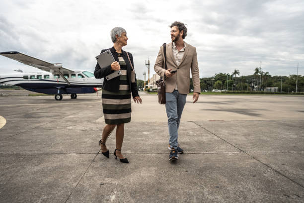 istock Coworkers talking while walk in the airport hangar 1487558874