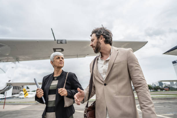 istock Coworkers talking while walk in the airport hangar 1487558920