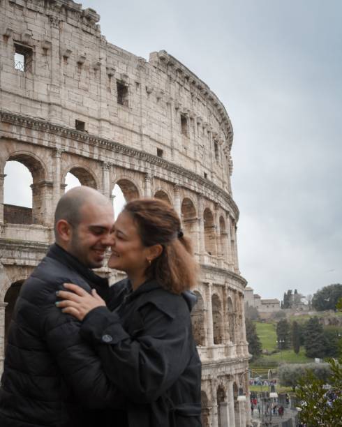 istock a couple hugging while posing in front of the colosseum in rome 1487559097