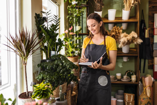 istock Woman working at flower shop checking notes 1487559187