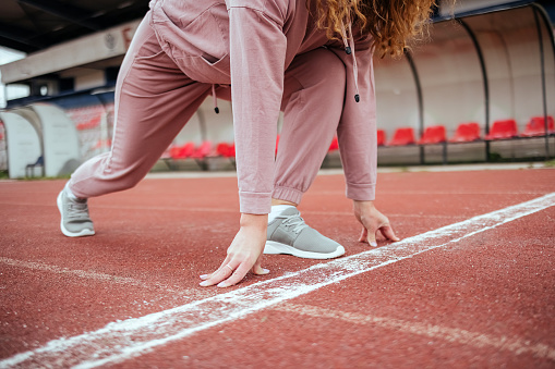 Woman on running track in starting position