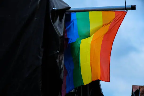 Photo of The rainbow flag flying in the wind after rain. Montage of the scene for the Gay Pride event.