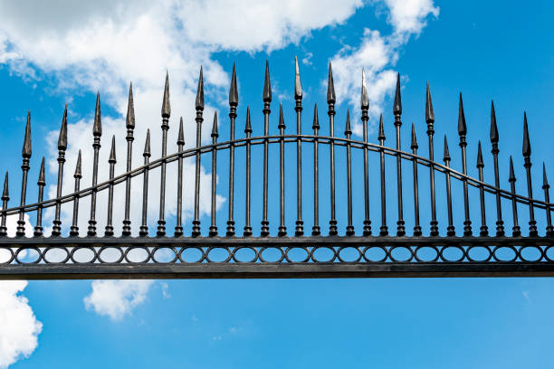 istock Wrought iron, old, decorative fence with blue sky in the background 1487565543