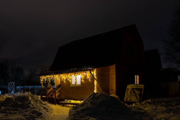 istock Christmas lights on wooden house at night 1487565783