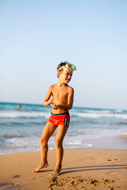 Boy with scuba mask playing on the beach