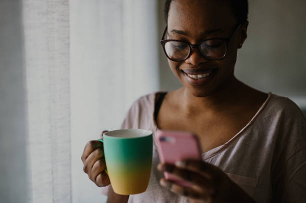 istock African american woman using smartphone while drinking coffee at home 1487568200