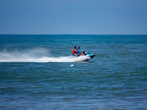 Nuevo Vallarta, Nayarit, Mexico-April 17, 2023: Couple on a speeding jet ski in the ocean, Nuevo Vallarta, Mexico.