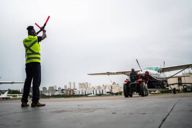 istock Man signaling the pilot with marshalling wands on airport 1487574208