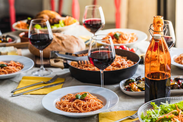 istock Big table of a restaurant setting with selective focus on a plate of spaghetti 1487574565