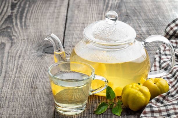 hot quince tea in transparent teapot with fresh fruits on wooden table - quince imagens e fotografias de stock