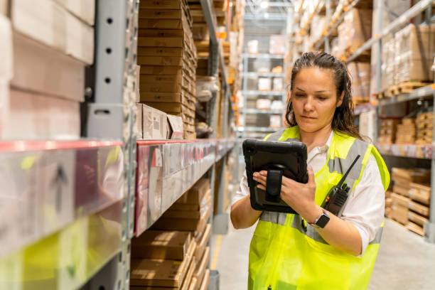 istock A mature woman warehouse worker is standing next to a shelf and using a digital tablet. 1487575683