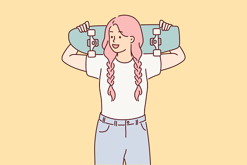 Teenager girl holds skateboard in hands, wanting to ride through city streets or park with skate ramp. Schoolgirl with pink hair loves to skateboard and do extreme sports after college