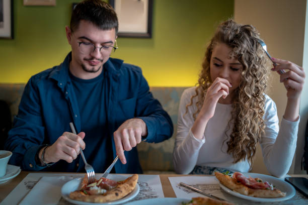 istock Happy couple talking while eating pizza for lunch 1487576406
