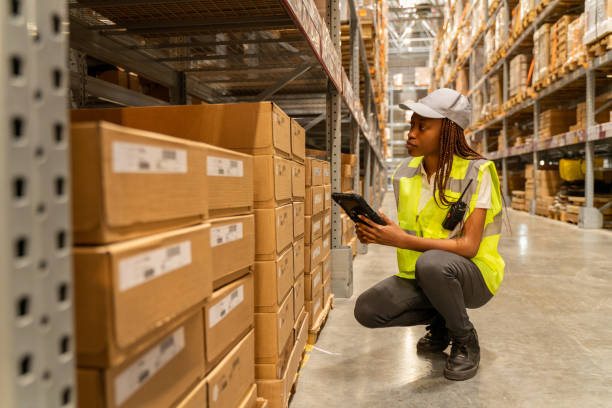 istock A black woman warehouse  worker is standing next to a shelf and using a digital tablet. 1487576480