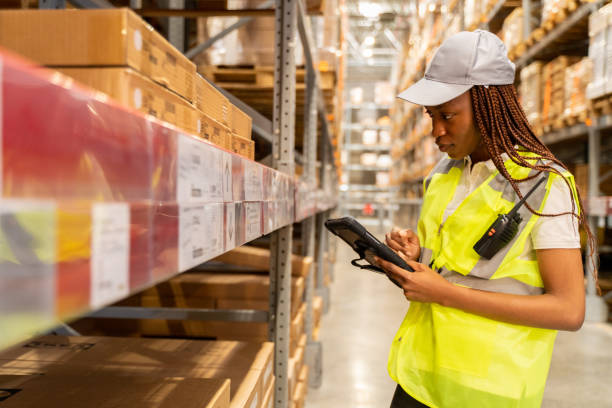 istock A black woman warehouse  worker is standing next to a shelf and using a digital tablet. 1487576753