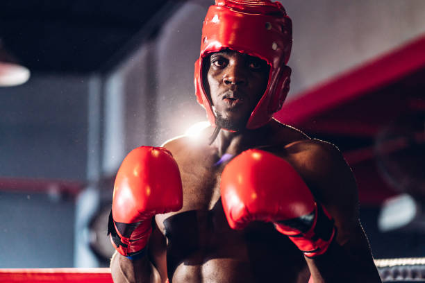 istock Boxer preparing for training in Boxing Club. Confident boxer standing in pose and ready to fight. Boxing fighters training at gym 1487580013