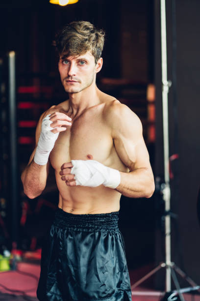 istock Boxer training in Boxing Club. Boxing fighters training at gym. Strong muscular Man practicing box in gym. 1487580069