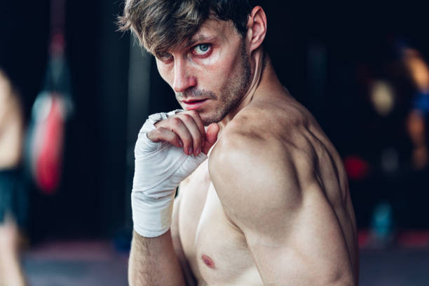 istock Boxer training in Boxing Club. Boxing fighters training at gym. Strong muscular Man practicing box in gym. 1487580077