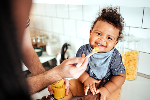 Father feeds his baby in the kitchen
