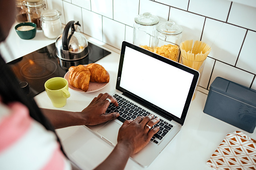 Woman using laptop in the kitchen