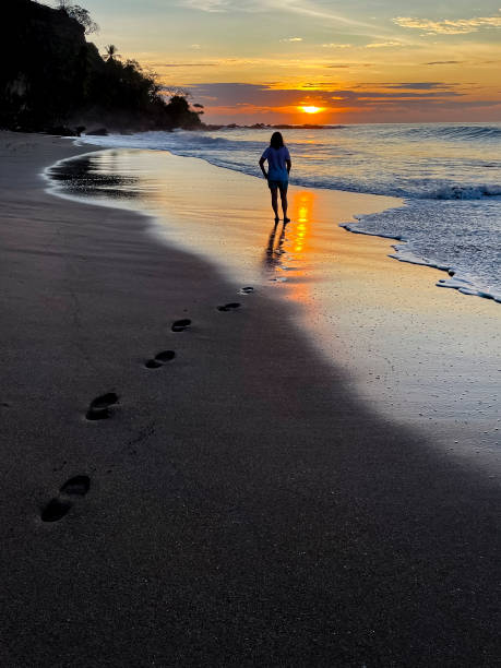 istock Woman walking on the beach sunrise 1487582796